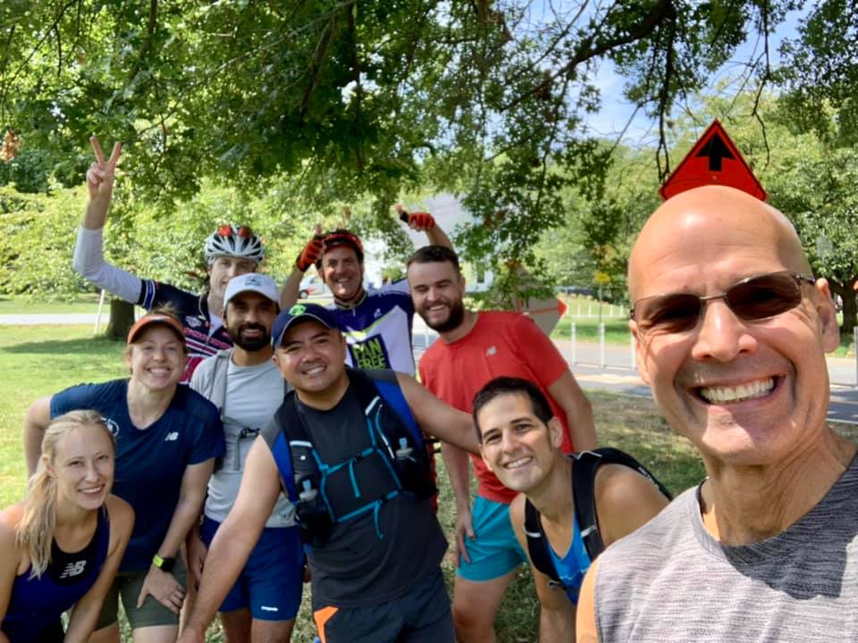a picture of Miguel Cuya (center) standing with several members of DC Road Runners celebrating his 45-mile birthday run