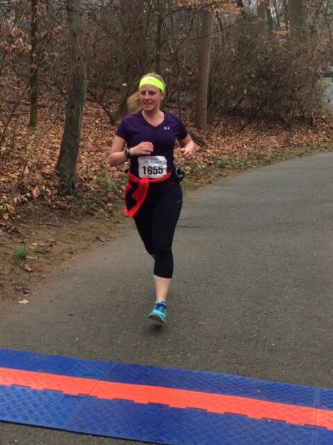 Kelly Fisher crossing the finish line of a DC Road Runners race